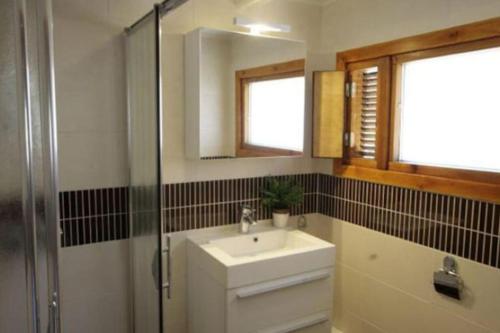 ein Badezimmer mit Waschbecken, Dusche und Spiegel in der Unterkunft Finse bungalow max 5 volwassenen + 3 kinderen in Otterlo