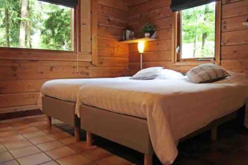 ein Schlafzimmer mit einem großen Bett in einem Blockhaus in der Unterkunft Finse bungalow max 5 volwassenen + 3 kinderen in Otterlo