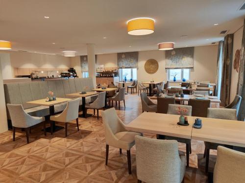 restauracja ze stołami i krzesłami oraz bar w obiekcie Hotel Lutz w mieście Rain