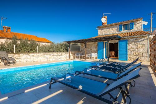 a blue boat sitting on a patio next to a swimming pool at Rustic villa casa Nadalina with pool in Visnjan in Radovani