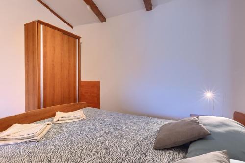 a bedroom with a bed and a wooden cabinet at Rustic villa casa Nadalina with pool in Visnjan in Radovani