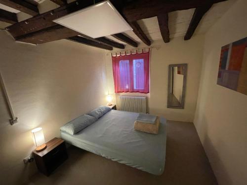 a bedroom with a large bed and a window at Attic in the Old Town in Modena