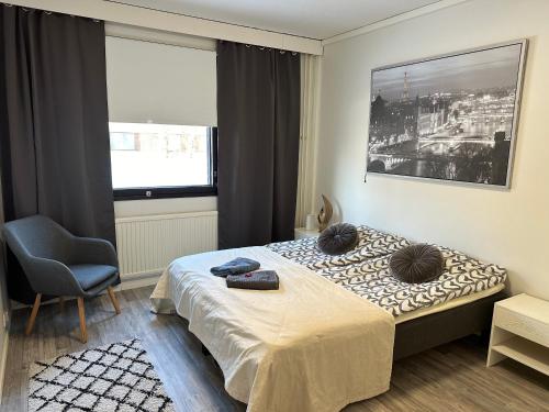 a bedroom with a bed and a chair and a window at 2BR with sauna in Tornio city in Tornio