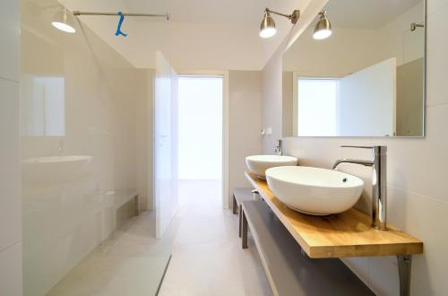 a white bathroom with two sinks and a tub at Villa Olivia in Vrh