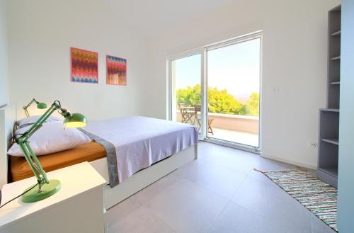 a bedroom with a bed and a large window at Villa Olivia in Vrh