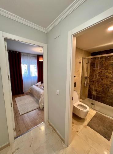 a bathroom with a bed and a shower and a toilet at Apartamentos Prestige Málaga Suites IV in Málaga