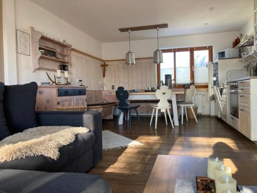 a living room with a couch and a kitchen at Bei uns im Allgäu - Ferienwohnungen zum Wohlfühlen in Bad Wurzach