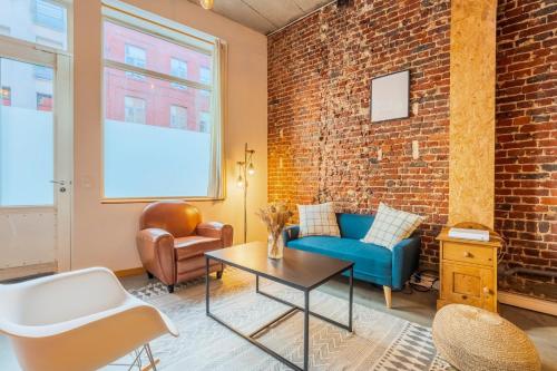 - un salon avec un mur en briques dans l'établissement 2 bedroom souplex apartment with terrace, à Lille
