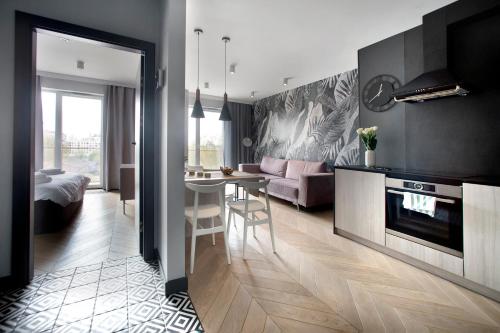 una cucina e un soggiorno con tavolo e divano di Praga Zupnicza P&O Serviced Apartments a Varsavia
