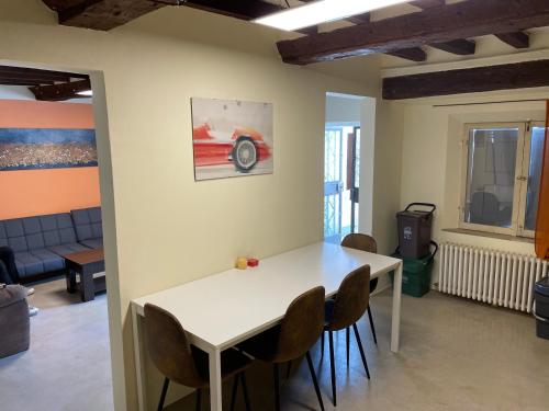 a dining room with a white table and chairs at Attic in the Old Town in Modena
