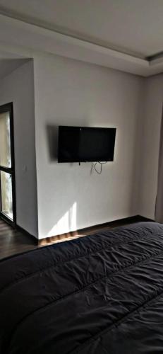 een slaapkamer met een flatscreen-tv aan de muur bij اقامة مفتاح الساحل in Agadir