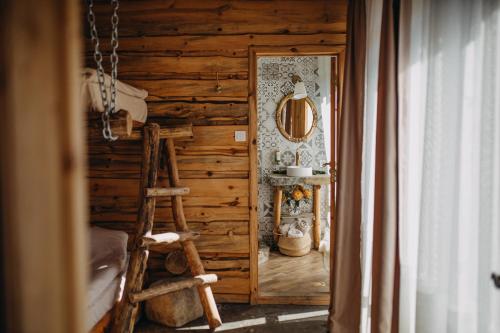 a wooden room with a ladder and a mirror at Bedouin Forest Residence in Valevtsi