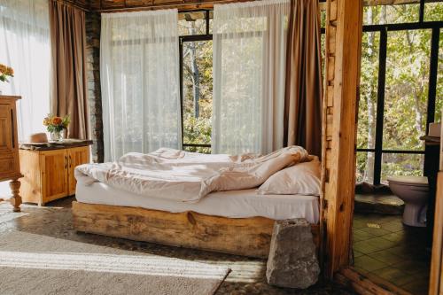 a bed sitting in a room with a window at Bedouin Forest Residence in Valevtsi