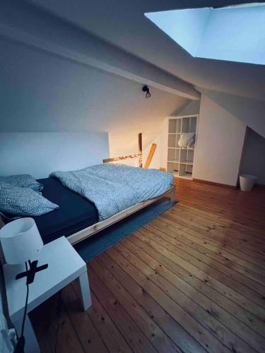 - une chambre avec un grand lit et du parquet dans l'établissement Appartement net buiten stadskern, à Hasselt
