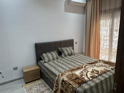 a bedroom with a bed with pillows and a window at Studio ain Zaghouan nord la marsa استديو عين زغوان الشمالية المرسى in Tunis