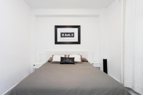 un letto in una camera con pareti bianche di Home2Book Cozy Apt La Marina, Santa Cruz Center a Santa Cruz de Tenerife