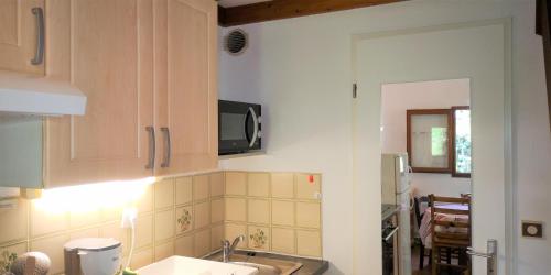 een keuken met een wastafel en een magnetron bij Résidence Cap Azur Maison N° 6 in Villeneuve-Loubet