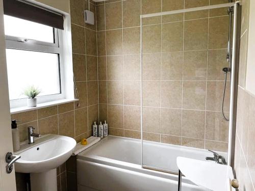 a bathroom with a tub and a sink and a shower at Little Harries Cottage - surrounded by open fields in Ripon