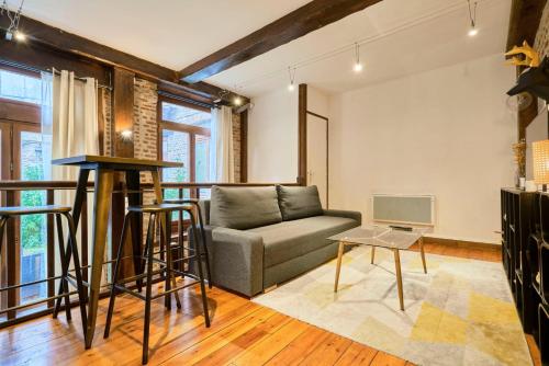 a living room with a couch and a table at Atypical apartment in the heart of Old Lille! in Lille
