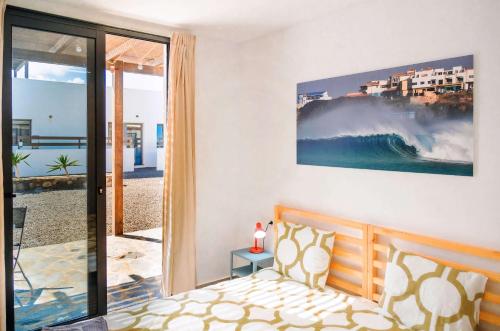 a bedroom with a bed and a large painting on the wall at NaoClub Fuerteventura in Lajares