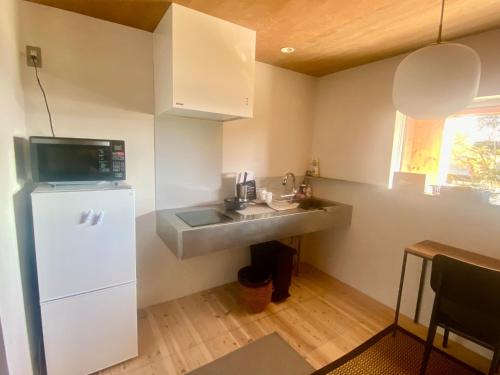 a small kitchen with a sink and a refrigerator at Togaku Hokosha Female -over16 years old- Only Guest House - Vacation STAY 15724 in Nagano