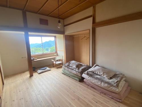 a living room with a couch and a large window at Togaku Hokosha Female -over16 years old- Only Guest House - Vacation STAY 15724 in Nagano