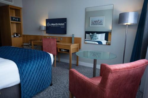 a hotel room with a bed and a desk and a table at CityNorth Hotel & Conference Centre in Gormanston