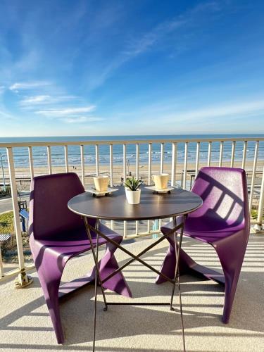 a table and two chairs on a balcony with the ocean at T2 La vue panoramique sur l'océan à 180 in Saint-Jean-de-Monts