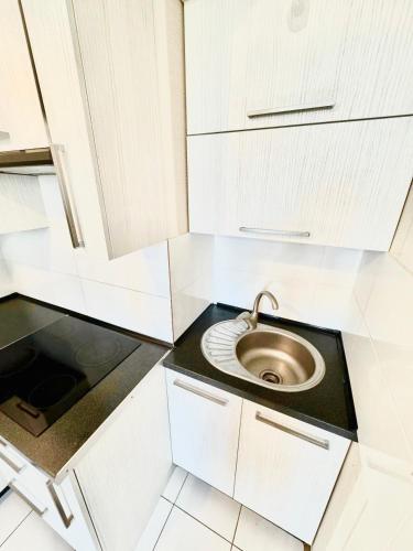 una pequeña cocina blanca con fregadero. en Little home Center apartament en Chişinău
