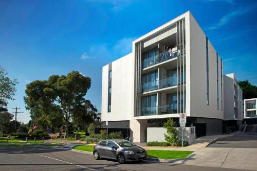 a car parked in front of a white building at Retro Modern with Pool near Westfield Doncaster in Melbourne