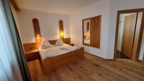a bedroom with a bed and a large mirror at Alpenspitz Appartements - Garni - B&B in Racines