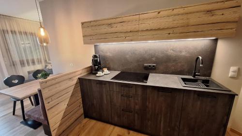 a kitchen with a sink and a counter top at Alpenspitz Appartements - Garni - B&B in Racines
