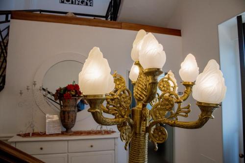 una lampada dorata in una stanza con specchio di Palazzo Montagna a Melissano