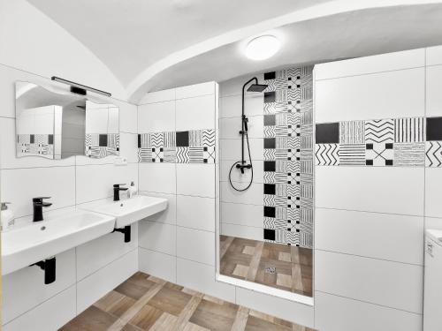 a white bathroom with two sinks and a shower at Marcelína in Mikulov v Krušných Horách