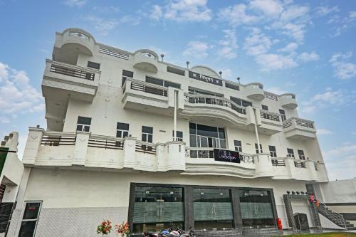 a large white building with balconies on top of it at OYO Flagship Hotel Tri Palace in Kānpur