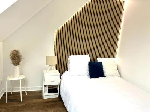 a bedroom with a bed with a wooden headboard at MARNELLY Maison Ploemeur 4 adultes et 1 enfants avec jardin privatif exposé sud in Ploemeur