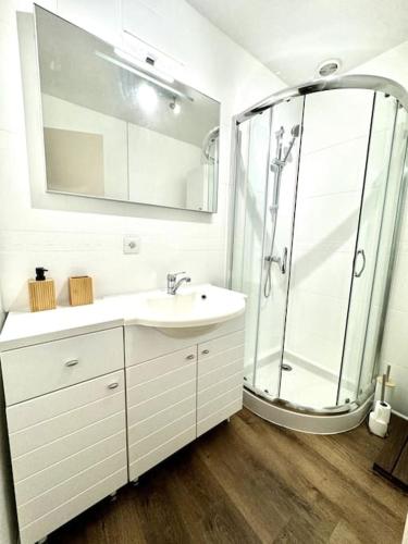 une salle de bain blanche avec une douche et un lavabo dans l'établissement MARNELLY Maison Ploemeur 4 adultes et 1 enfants avec jardin privatif exposé sud, à Ploemeur