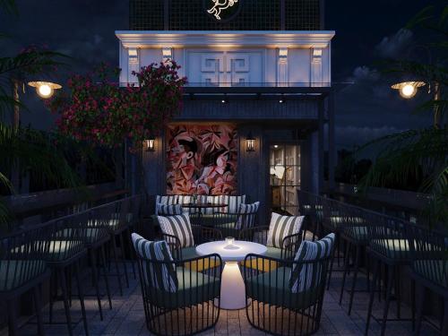 a patio with chairs and a table in front of a building at Victor Metropolis Hotel & rooftop Bar In Hanoi city in Hanoi