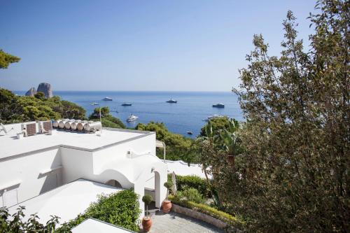a view of the ocean from a white house at LHP Suite Superior Cottage Capri in Capri