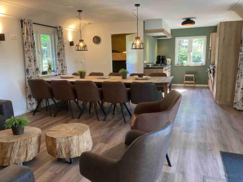 sala de estar con mesa y sillas y cocina en Familiehuis de Lariks - 12 persoons villa op de Veluwe, en Otterlo