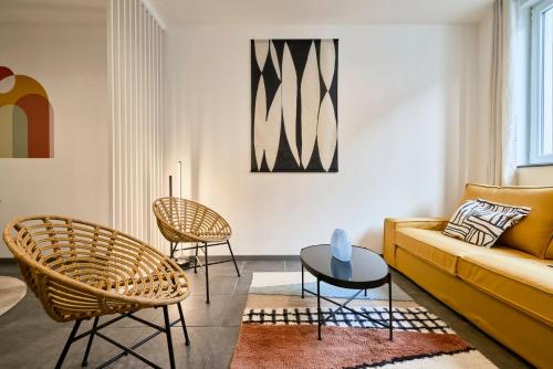 a living room with a yellow couch and chairs at 3 bedroom house with courtyard, near metro in Tourcoing