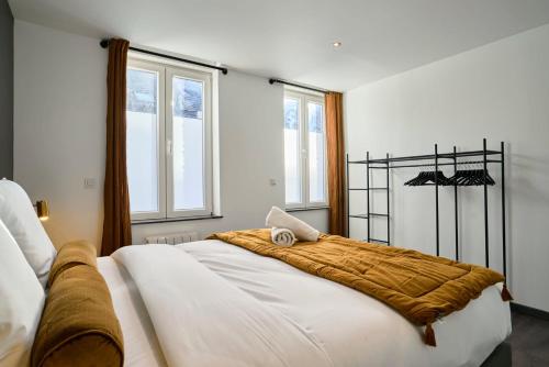Un dormitorio con una cama grande con una manta. en 3 bedroom house with courtyard, near metro en Tourcoing