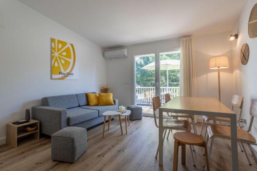 Lecci的住宿－Fiori di Cala Rossa résidence hôtelière，客厅配有蓝色的沙发和桌子