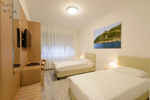 a hotel room with two beds and a tv at Hotel Ceresio in Lugano