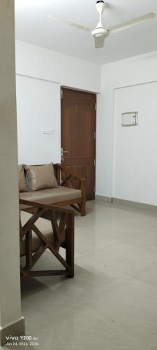 uma sala de estar com um banco e uma porta em VV ROOMS cochin internationalairport em Nedumbassery