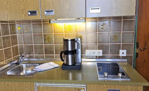 a coffeemaker sitting on a kitchen counter next to a sink at Schneck Apartments in Schönau am Königssee