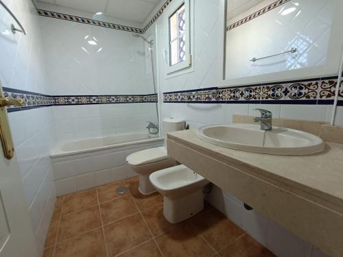 Un baño con lavabo, inodoro y bañera. en Urbanización San bruno II en segunda planta., en Isla Canela