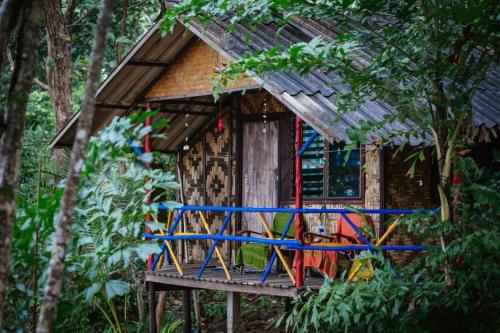 a tree house with a deck in the woods at Simple Life Bungalows in Ko Jum