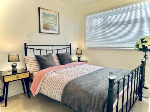 a bedroom with a bed and a window at Entire 5 bedroom detached house free Parking 5 mins driving to Bicester Village in Bicester