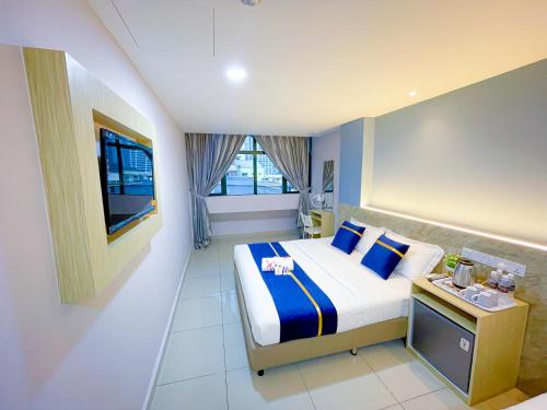 クアラルンプールにあるStarQ Hotel Bukit Bintangのベッドとテレビが備わるホテルルームです。